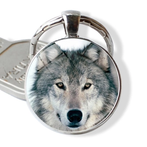 Détail du porte-clés loup en métal argenté avec photo de loup réaliste et dôme de verre bombé