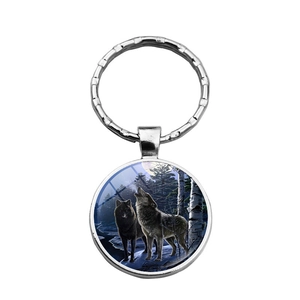 Détail du porte-clés rond argenté avec un motif artistique de loup hurlant