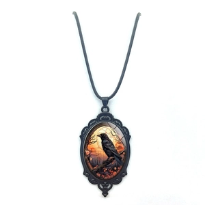 Oval crow pendant necklace with raven on cherry blossom branch and black leather cord