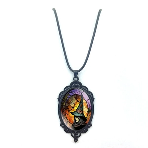 Detailed view of Gothic witch pendant with intricate black filigree frame and wax rope chain