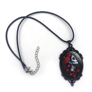 Macro shot of Gothic oval necklace featuring a skull lady with red roses and black cord