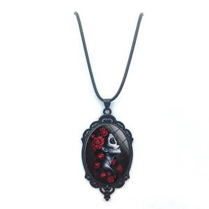 Vintage necklace featuring a black skull girl pendant with red roses on a black cord