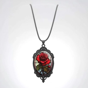 Detail of vintage oval pendant with red rose and decorative black metal frame