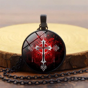 Close-up of a Gothic glass dome pendant necklace with a red cross and rose patterns