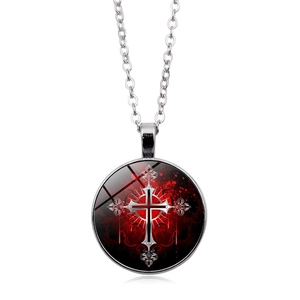 Macro view of vintage Gothic round pendant necklace with red cross and rose motif