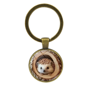 Portachiavi con ciondolo a forma di riccio nel buco dell'albero e anello in bronzo