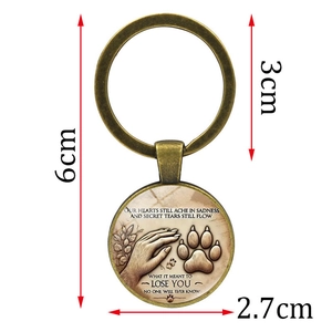 Memorial pet paw print keychain with bronze pendant and sentimental quote on white background