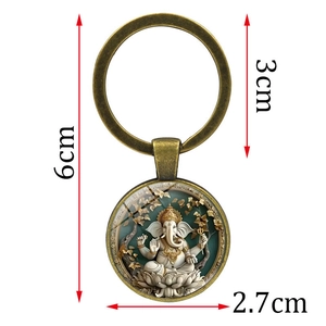 Ganesha metal keychain with colorful glass dome pendant on white background