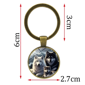 Bronze wolf family keychain with round glass pendant showing white and black wolves