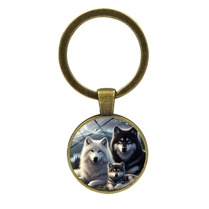 Vintage bronze wolf family keychain featuring a snowy mountain scene with glass dome