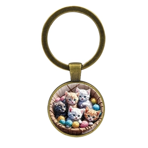 Porte-clés rond en bronze avec illustration de famille de chats et chatons dans un panier
