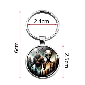 Bigfoot and alien time gem keychain in silver metal with forest and UFO illustration