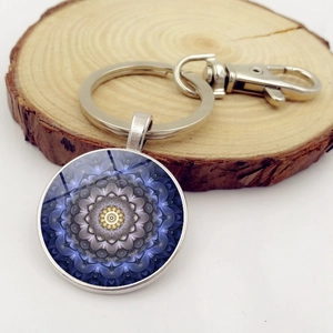 Dettaglio portachiavi cabochon in vetro con motivo mandala su base in legno naturale
