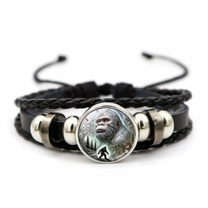 Macro shot of multi-layer leather bracelet with Bigfoot silhouette glass cabochon charm