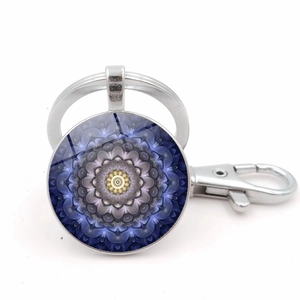 Dettaglio ravvicinato di un ciondolo mandala in vetro blu su un portachiavi in metallo argento