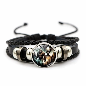 Close-up of multilayer braided leather bracelet with Bigfoot and alien glass dome charm