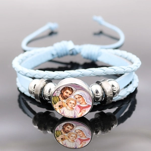 Macro view of blue braided leather bracelet with Virgin Mary glass cabochon pendant
