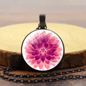 Nahaufnahme des rosa Lotus-Glasanhängers mit retro schwarzer Legierungskette auf Holz