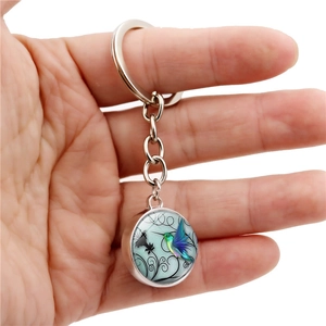 Detail of hummingbird glass pendant with vintage patterns on a zinc alloy keychain