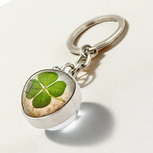 Macro view of silver four-leaf clover keychain with vintage double-sided crystal glass ball