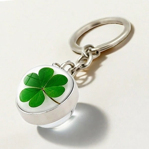 Detail of four-leaf clover keychain with double-sided crystal ball and silver metal ring