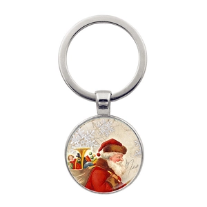 Detalle de un llavero de metal plateado con diseño vintage de Papá Noel y matasellos