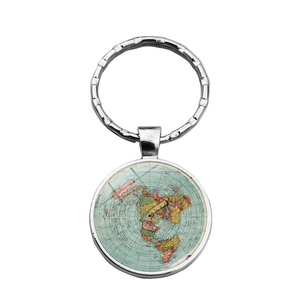 Detail of vintage silver metal keychain featuring a round world map map pendant charm