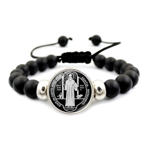 Dettaglio di perline nere opache e medaglia di San Benedetto su bracciale religioso