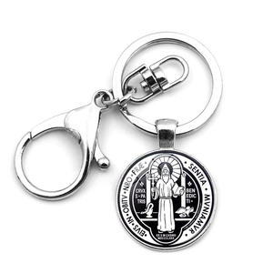 Detail of Saint Benedict medal keychain with lobster clasp and metal texture view
