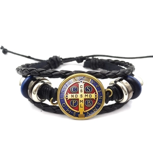 Detailansicht der Benediktus-Medaille auf geflochtenem Lederarmband mit blauen Perlen