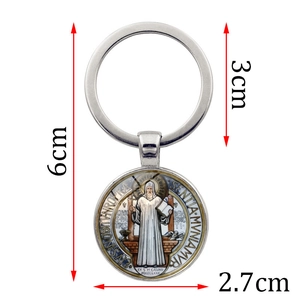 Macro detail showing the St. Benedict medal keychain dimensions and metal texture