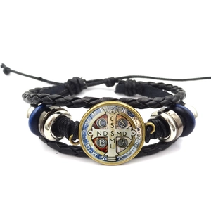 Detail der Benediktus-Medaille auf mehrlagigem Lederarmband mit blauen Holzperlen und Metall