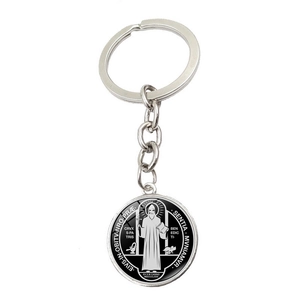 Close-up of Saint Benedict Medal keychain in silver metal with black and white enamel detail