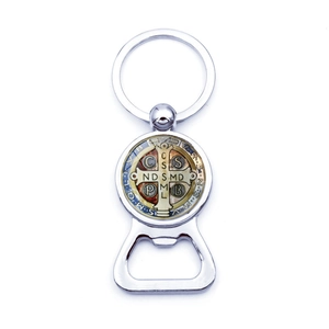 Detailed macro view of Saint Benedict silver medal and integrated bottle opener keychain