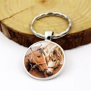 Artistic horse head pendant keychain with silver alloy ring on wooden surface