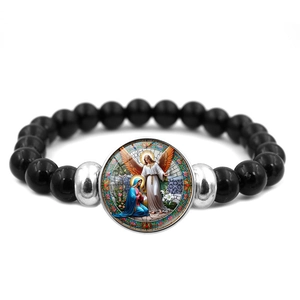 Close-up of Saint Michael beaded bracelet with religious Annunciation charm on white base
