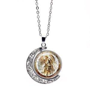 Detail of St. Michael Archangel rotating moon pendant with intricate hollow carvings