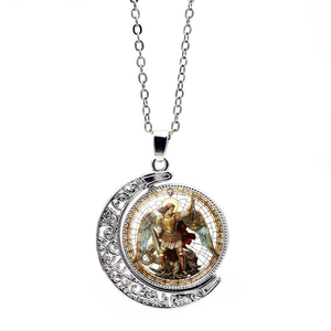 Detail of Archangel Michael rotating moon pendant with intricate silver scroll patterns
