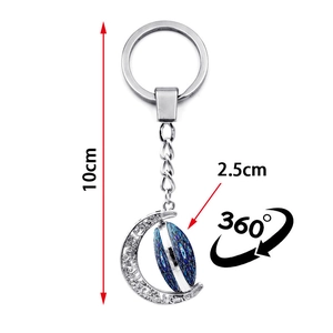 Detailed macro view of 10cm rotating moon evil eye keychain with silver floral hollow design