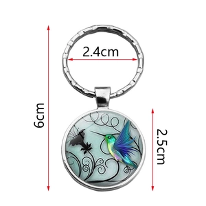 Llavero de colibrí de cristal con anillo de metal plateado y colgante motivo floral