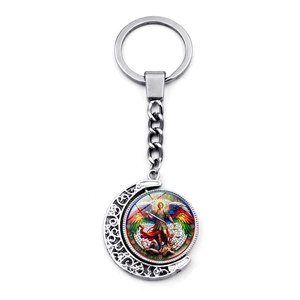 Detail of St. Michael keychain featuring a rotating moon pendant with hollow floral patterns
