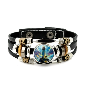 Detail of multi-layer leather bracelet featuring a lighthouse glass dome and snap clasp