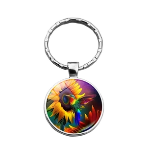 Llavero artístico con colibrí y girasol bajo cúpula de cristal y anillo metal
