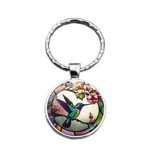Llavero redondo de cristal cabujón con colibrí y flores en metal plateado