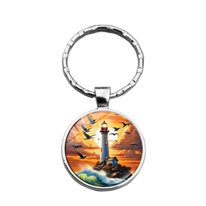 Detail of nautical lighthouse sunset illustration inside a glass dome keychain