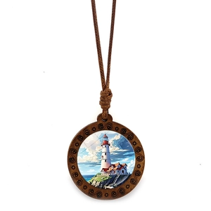 Close-up of a lighthouse wood pendant with detailed spiral carvings on a brown wax cord