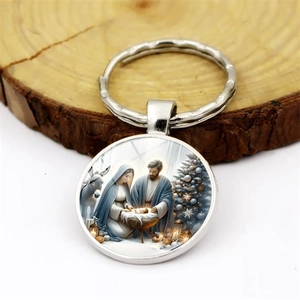 Silver metal religious Christmas keychain with nativity scene on a rustic wood background