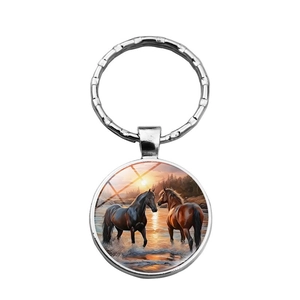 Silver keychain with glass gem pendant showing horses at sunset in a circular metal frame