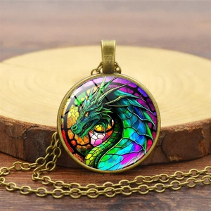 Detail view of fantasy green dragon pendant with bronze frame on a wooden surface