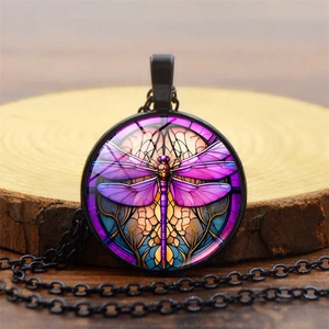 Macro shot of retro dragonfly pendant with colorful stained glass pattern on a wooden base